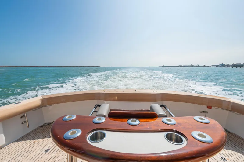 Slide: The Image of 2011 Viking 70 Convertible yacht cruising on open water, featuring a sleek deck design. - 31