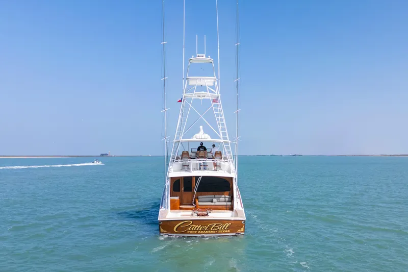 Slide: The Image of 2011 Viking 70 Convertible yacht cruising in a coastal waterway near a cityscape. - 56