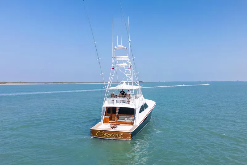 Slide: The Image of 2011 Viking 70 Convertible yacht cruising on calm waters near a marina. - 57