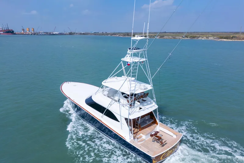 Slide: The Image of 2011 Viking 70 Convertible yacht cruising in open water near a coastal city. - 58