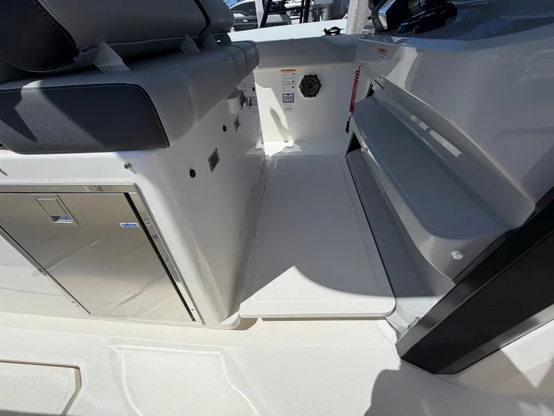 Slide: The Image of Interior of a 2026 Boston Whaler 330 Outrage with seating and storage area. - 31