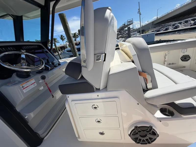 Slide: The Image of The image shows the helm of a Boston Whaler 330 Outrage with modern controls and comfortable seating. - 27