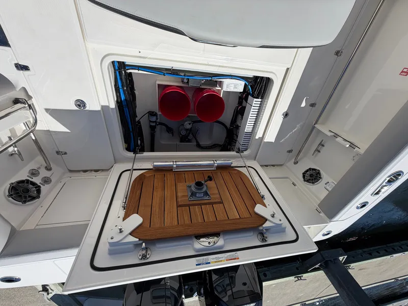 Slide: The Image of The image shows the engine compartment of a 2026 Boston Whaler 330 Outrage with an open cover. - 20