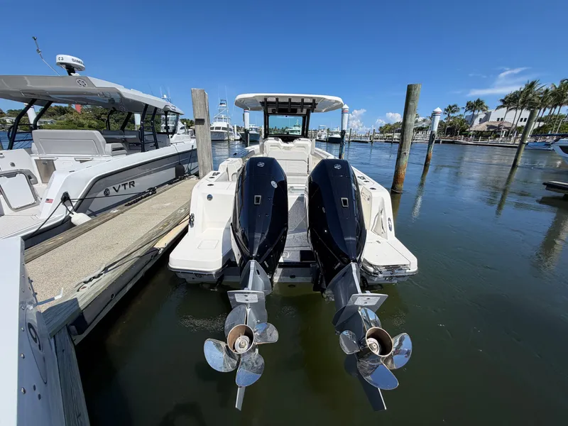 Slide: The Image of A 2026 Boston Whaler 330 Outrage docked. Two outboard engines are visible. - 16