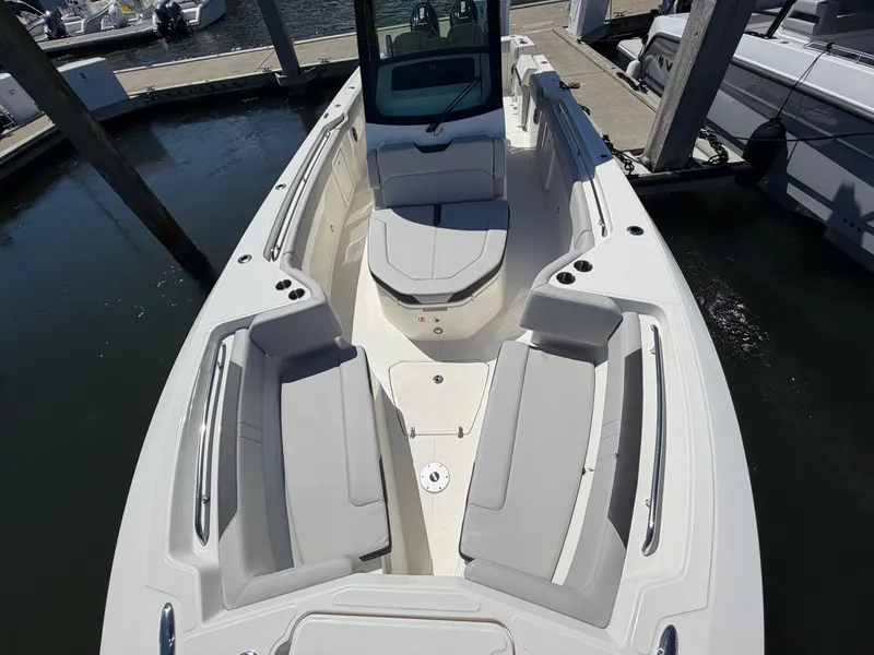 Slide: The Image of The image shows the deck of a Boston Whaler 330 Outrage with gray cushions and a central table. - 43