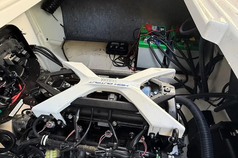 Slide: The Image of Engine compartment of a 2024 Yamaha Boats 252SE, showcasing mechanical components and wiring. - 18