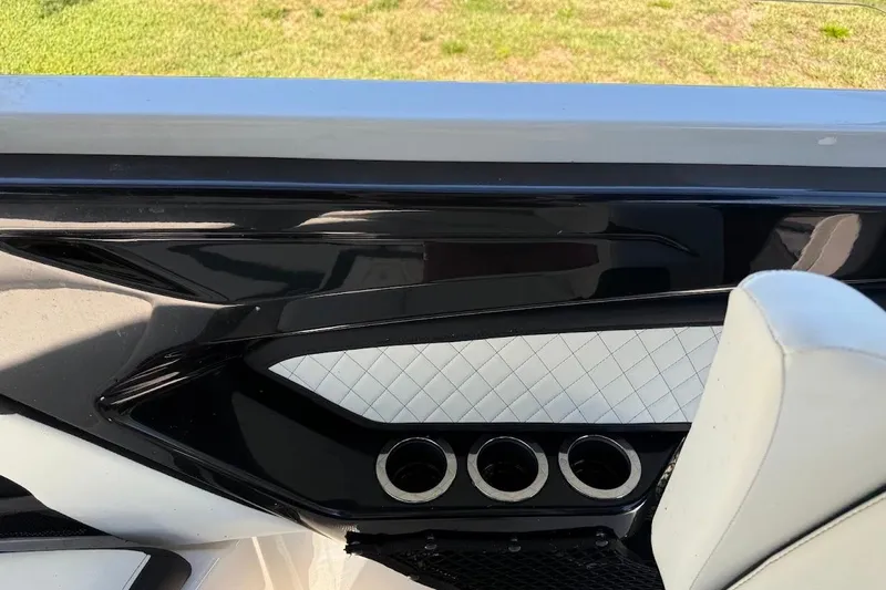 Slide: The Image of 2024 Yamaha Boats 252SE interior detail with sleek black and white design, cup holders visible. - 23