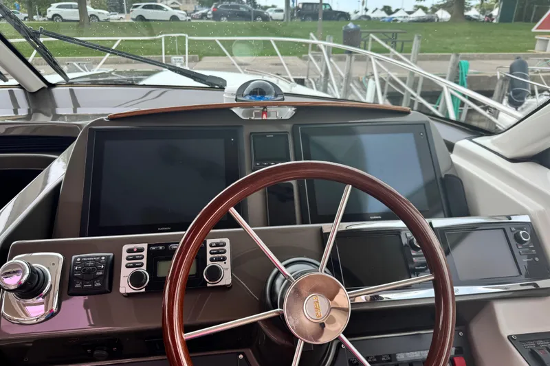Slide: The Image of Cockpit of 2014 Tiara Yachts 4300 Open with modern navigation equipment and wooden steering wheel. - 17