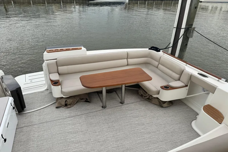 Slide: The Image of 2014 Tiara Yachts 4300 Open with elegant seating and wooden table on deck. - 28