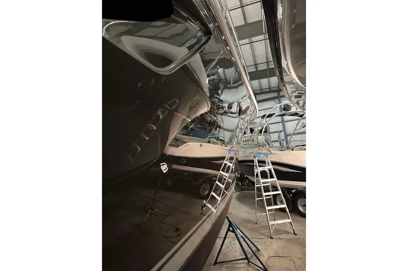 Slide: The Image of 2014 Tiara Yachts 4300 Open in a workshop with ladders and polished hull. - 35