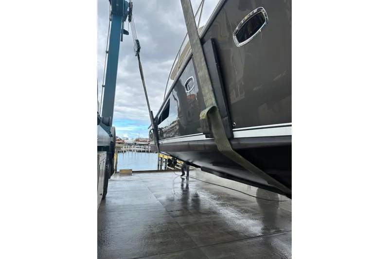 Slide: The Image of 2014 Tiara Yachts 4300 Open being lifted at a marina with overcast skies. - 39