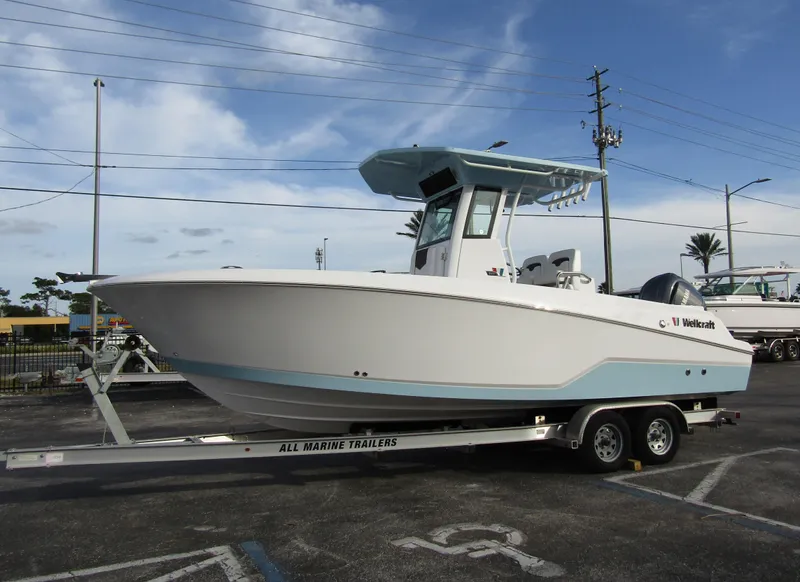 Slide: The Image of 2025 Wellcraft 243 Fisherman boat on trailer, parked outdoors under a cloudy sky. - 5