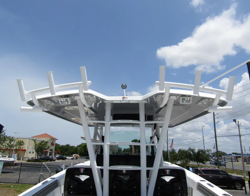 Slide: The Image of 2024 Wellcraft 352 Fisherman boat with T-top and rod holders under a clear sky. - 44