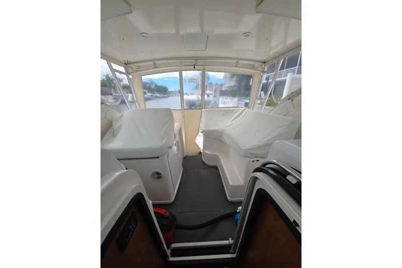 Slide: The Image of Interior view of 2006 Tiara Yachts 3600 Open, featuring covered seating and large windows. - 12