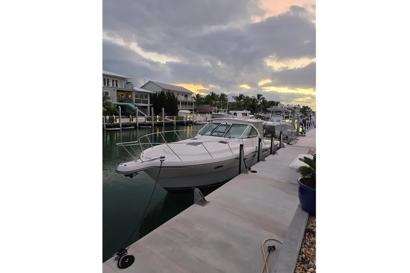 Slide: The Image of 2006 Tiara Yachts 3600 Open docked at sunset, with waterfront homes in the background. - 2