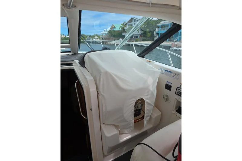 Slide: The Image of 2006 Tiara Yachts 3600 Open helm with protective cover, docked near waterfront homes. - 20