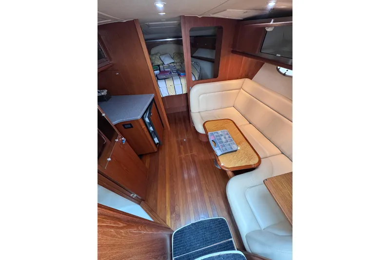 Slide: The Image of 2006 Tiara Yachts 3600 Open interior with wood flooring, beige seating, and compact kitchenette. - 22