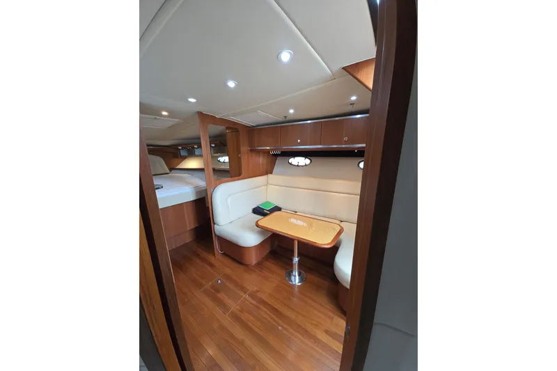 Slide: The Image of 2006 Tiara Yachts 3600 Open interior with cozy seating and wooden accents. - 24