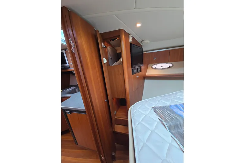Slide: The Image of 2006 Tiara Yachts 3600 Open interior with wood cabinetry and cozy sleeping area. - 27