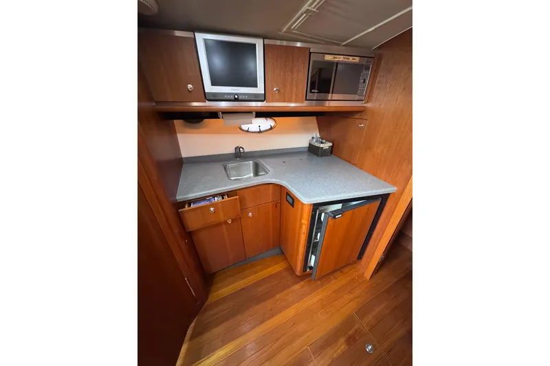 Slide: The Image of 2006 Tiara Yachts 3600 Open galley with wood cabinetry, sink, and appliances. - 29