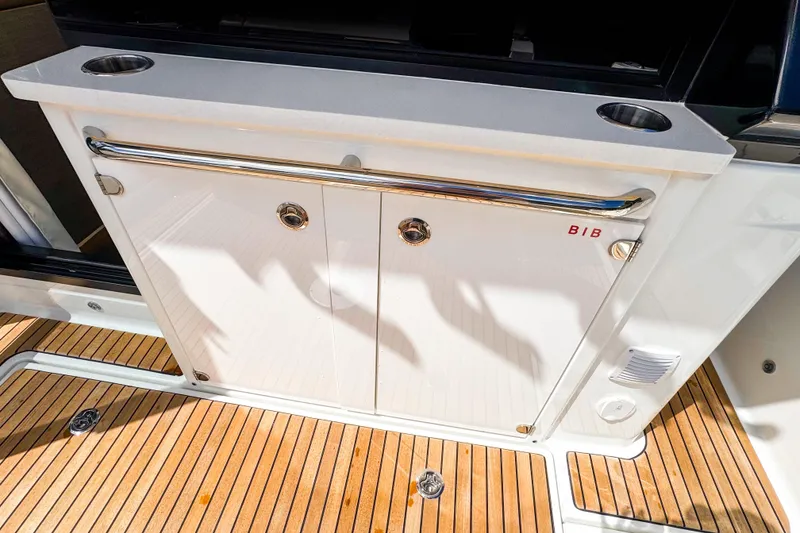 Slide: The Image of 2025 Wellcraft 38 Explorer yacht deck with storage cabinet and cup holders. - 17
