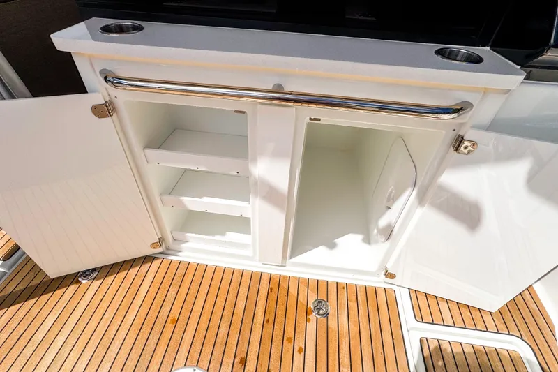 Slide: The Image of Open storage cabinet on 2025 Wellcraft 38 Explorer boat with wooden deck flooring. - 18