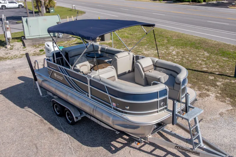 The Image of 2021 South Bay 222CR pontoon boat on trailer, featuring a canopy and spacious seating. - 0