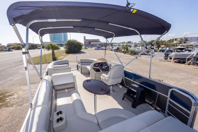 Slide: The Image of 2021 South Bay 222CR pontoon boat with canopy and seating, parked near marina. - 10