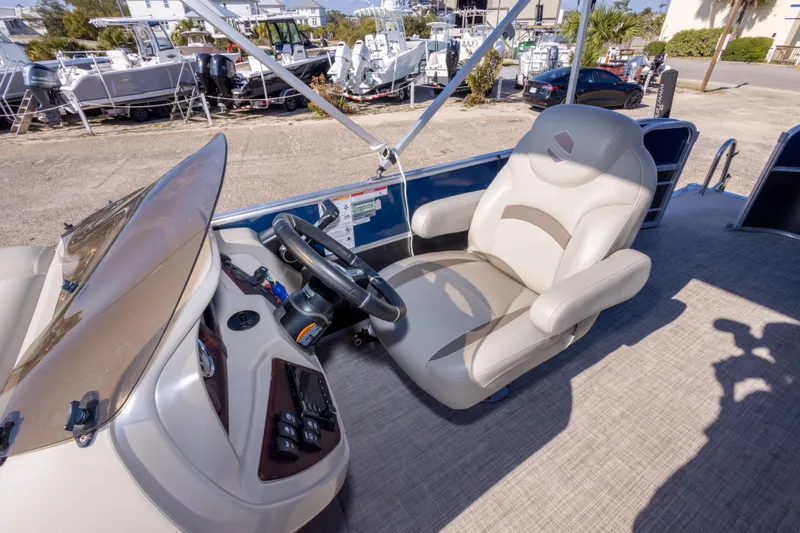 Slide: The Image of 2021 South Bay 222CR boat helm with steering wheel and captain's chair. - 13