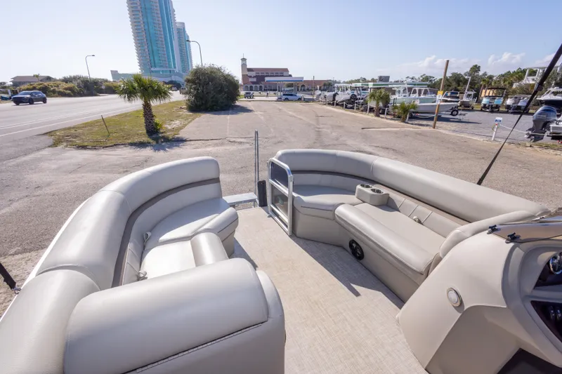 Slide: The Image of 2021 South Bay 222CR pontoon boat with spacious seating, parked near a marina. - 15