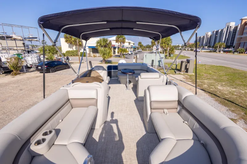 Slide: The Image of 2021 South Bay 222CR pontoon boat with spacious seating and canopy, parked outdoors. - 18