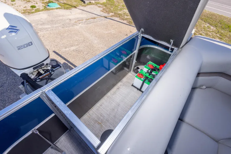 Slide: The Image of 2021 South Bay 222CR boat with open storage compartment and visible engine. - 19