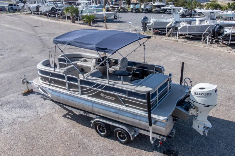 Slide: The Image of 2021 South Bay 222CR pontoon boat with Suzuki outboard motor, parked on a trailer. - 22