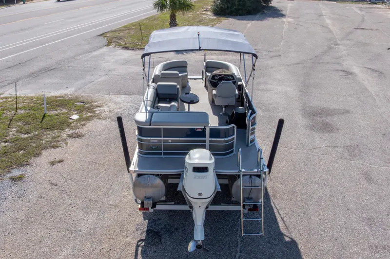 Slide: The Image of 2021 South Bay 222CR pontoon boat with canopy, parked on a paved area. - 23