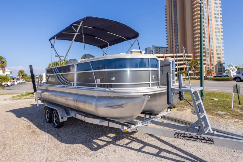Slide: The Image of 2021 South Bay 222CR pontoon boat on trailer near tall building. - 3