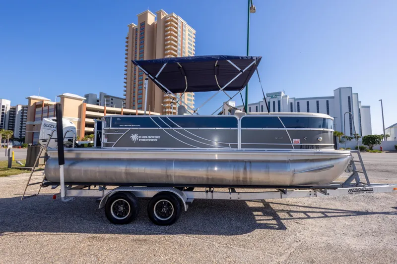 Slide: The Image of 2021 South Bay 222CR pontoon boat on trailer, cityscape background. - 4