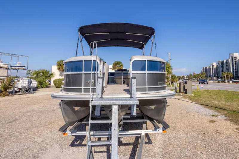 Slide: The Image of 2021 South Bay 222CR pontoon boat on trailer, parked outdoors under clear blue sky. - 8