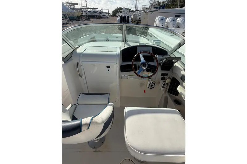Slide: The Image of 2004 Hurricane SunDeck 260 OB boat cockpit with steering wheel and seating. - 11