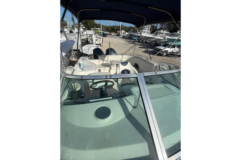 Slide: The Image of 2004 Hurricane SunDeck 260 OB boat with canopy, parked in a marina. - 12
