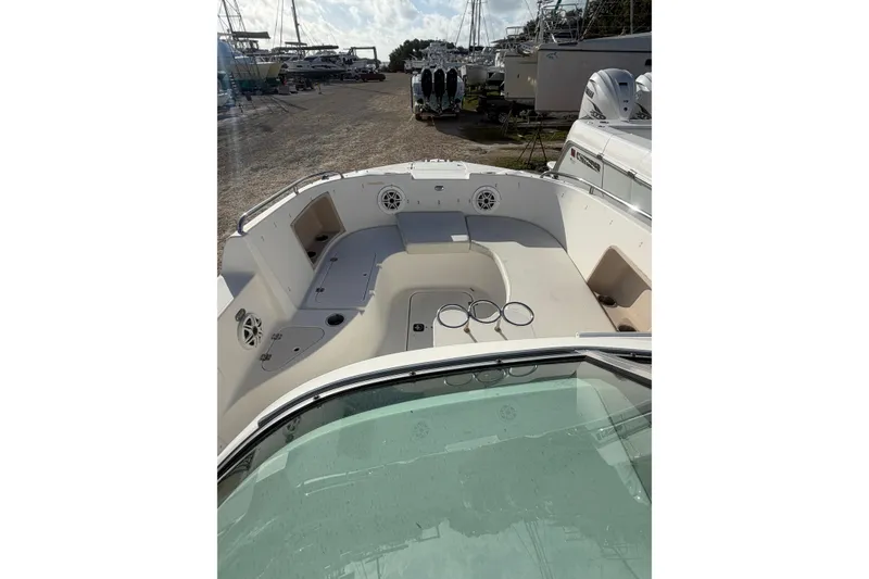 Slide: The Image of 2004 Hurricane SunDeck 260 OB boat interior with seating and cup holders, docked outdoors. - 16