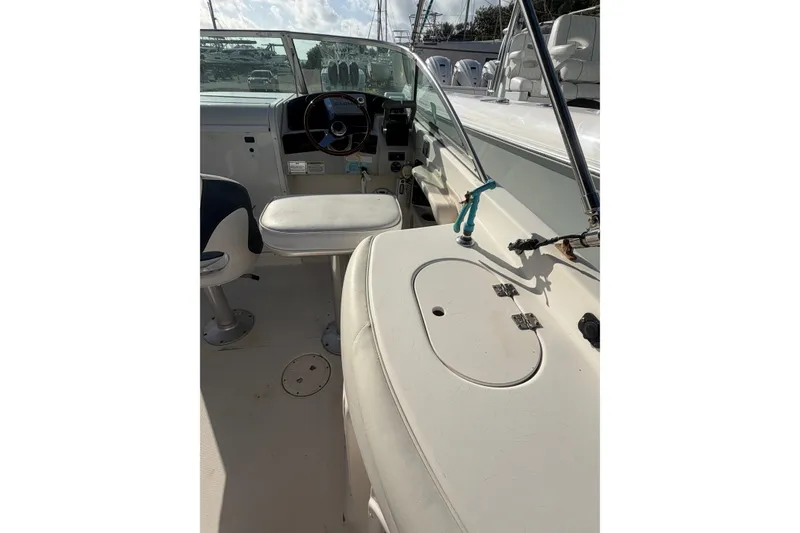 Slide: The Image of 2004 Hurricane SunDeck 260 OB boat interior with steering wheel and seating area. - 17