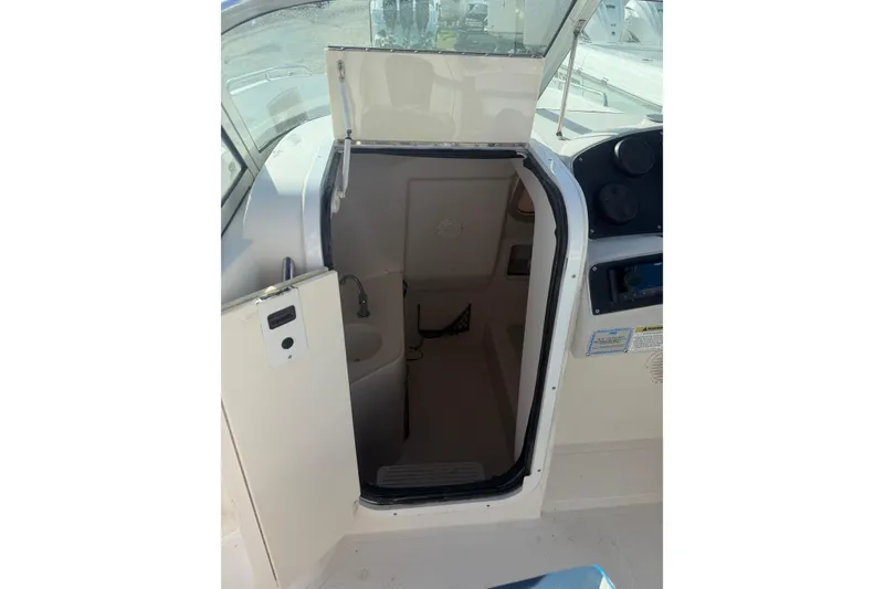 Slide: The Image of 2004 Hurricane SunDeck 260 OB boat interior cabin with open door and visible sink. - 21