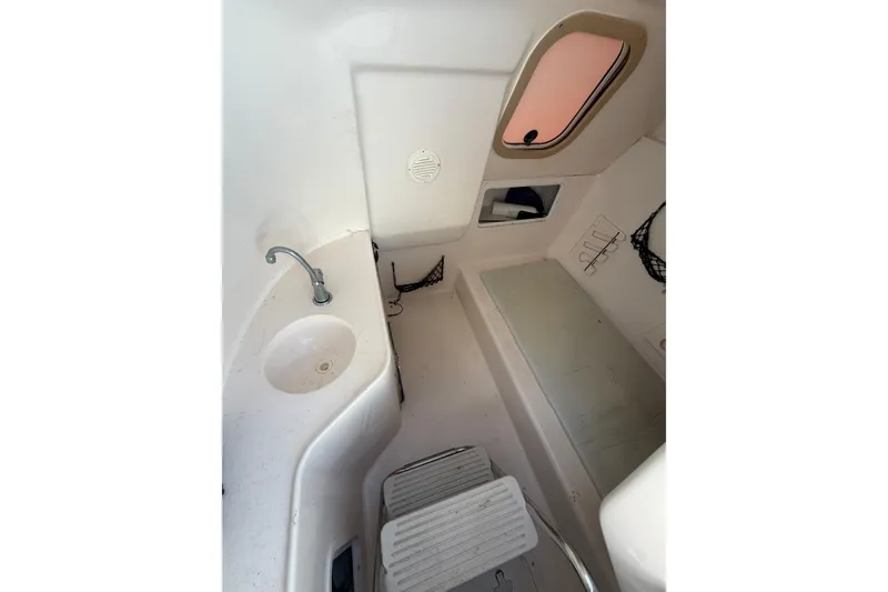 Slide: The Image of 2004 Hurricane SunDeck 260 OB interior cabin with sink and seating area. - 22