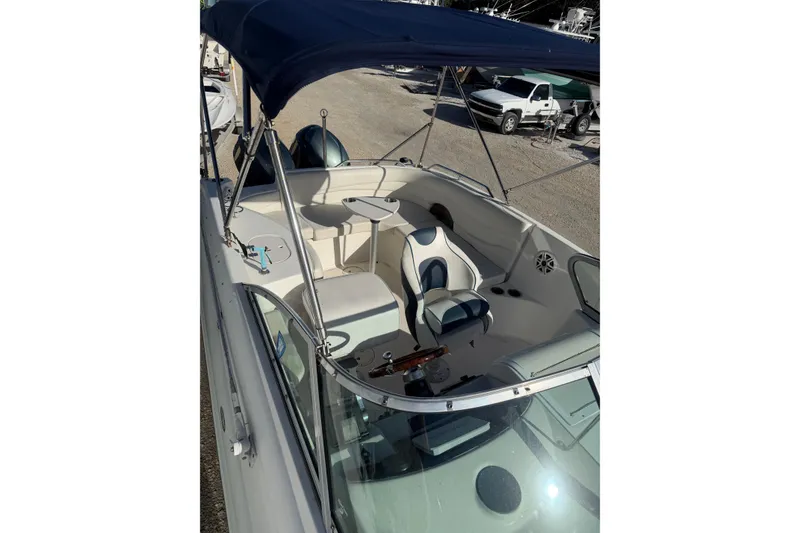 Slide: The Image of 2004 Hurricane SunDeck 260 OB boat with blue canopy and spacious seating. - 26