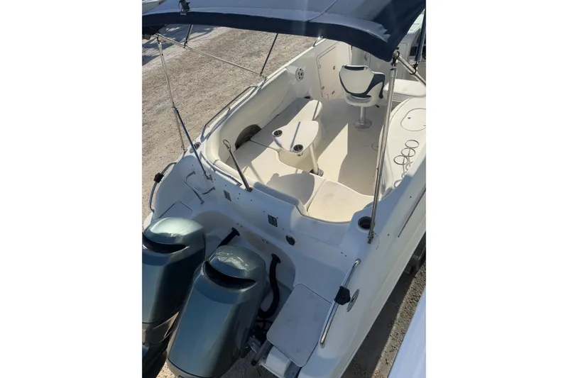 Slide: The Image of 2004 Hurricane SunDeck 260 OB boat with dual engines and spacious seating area. - 27