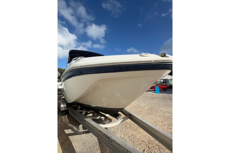 Slide: The Image of 2004 Hurricane SunDeck 260 OB boat on trailer under blue sky. - 6
