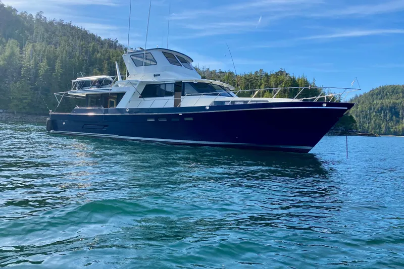 The Image of Nordlund 68 yacht from 1991 on serene water with forested backdrop. - 0