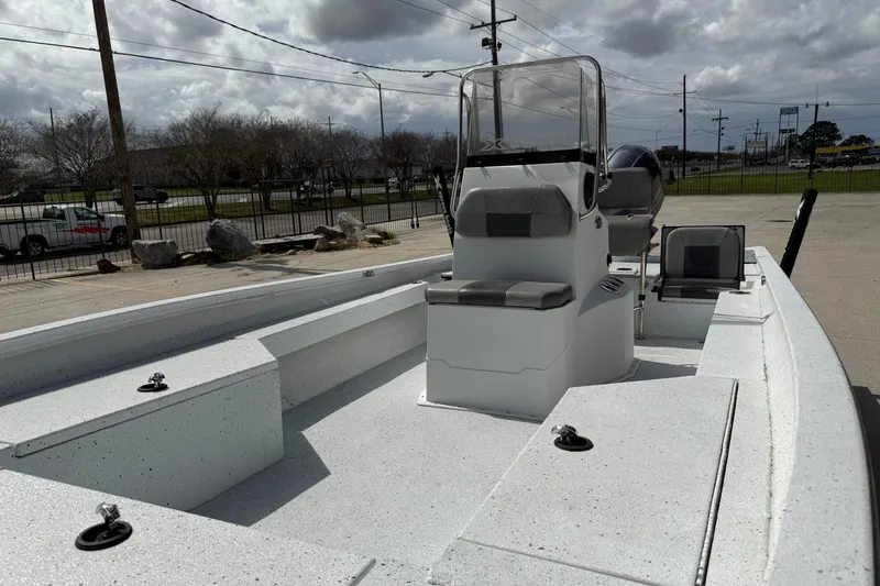 Slide: The Image of 2021 Xpress H24B Bay boat with center console, parked outdoors under cloudy skies. - 10