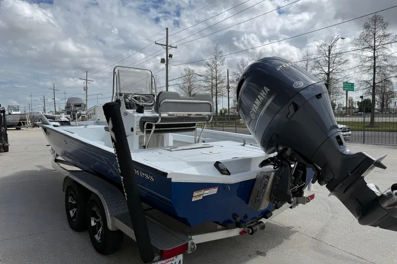 Slide: The Image of 2021 Xpress H24B Bay boat with Yamaha engine on trailer, parked outdoors. - 4