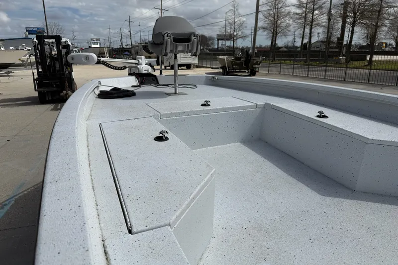 Slide: The Image of 2021 Xpress H24B Bay boat with spacious deck and seating, parked outdoors. - 8